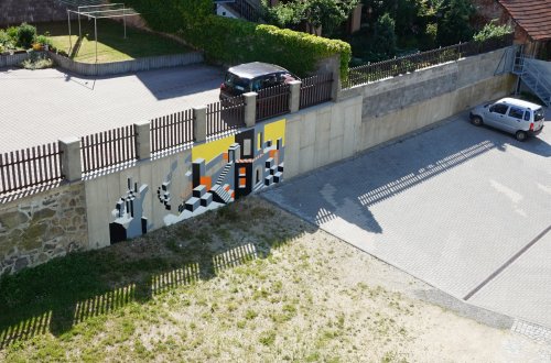 Nevzhledná zeď za školou se mění v umění