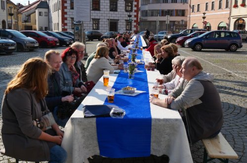 Lidé se sešli u dlouhého stolu a povídali si nejen o festivalu