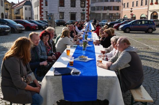Lidé se sešli u dlouhého stolu a povídali si nejen o festivalu